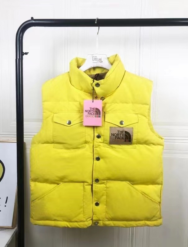 The North Face yellow puffer vest with logo patch
